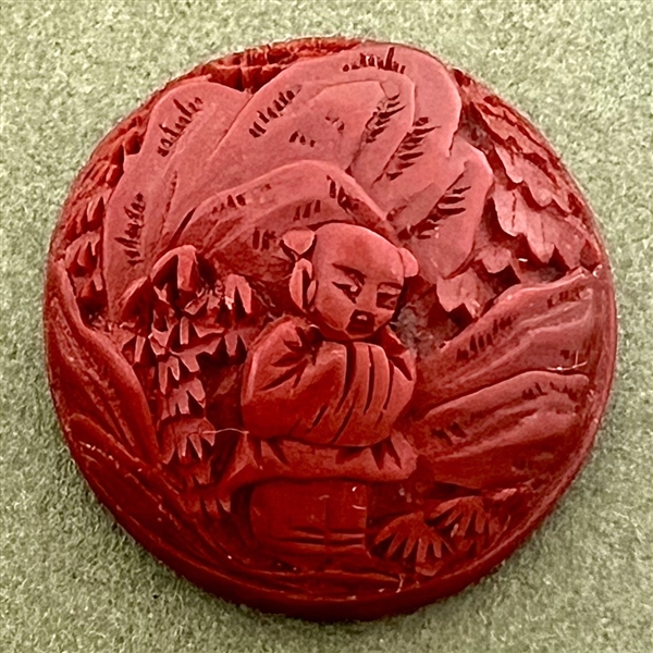 Chinese Cinnabar button of an Asian man in a garden.