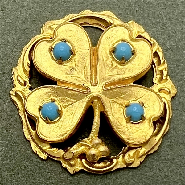 Gilded brass four-leaf clover button with turquoise glass.