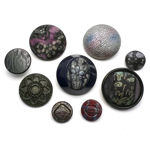 Nine assorted black glass imitation fabric buttons.