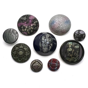 Nine assorted black glass imitation fabric buttons.