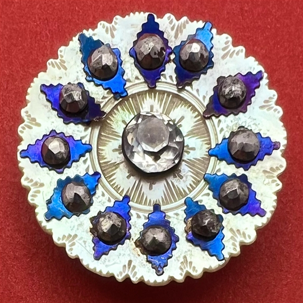 An 18th c. pearl button with blued steels and faceted paste pin shank  center.