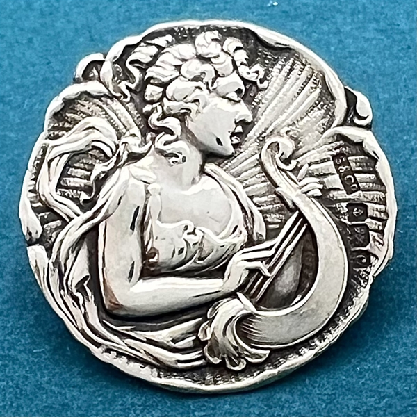 Hallmarked silver button of a “muse of music."