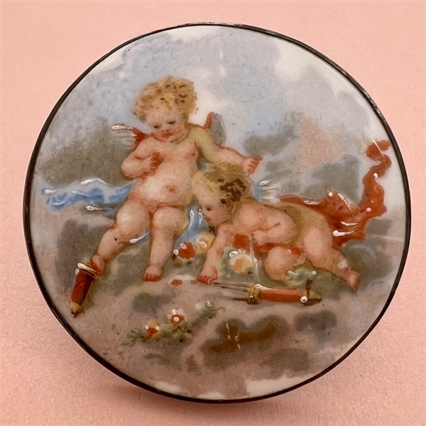 Ceramic button of two cherubs.