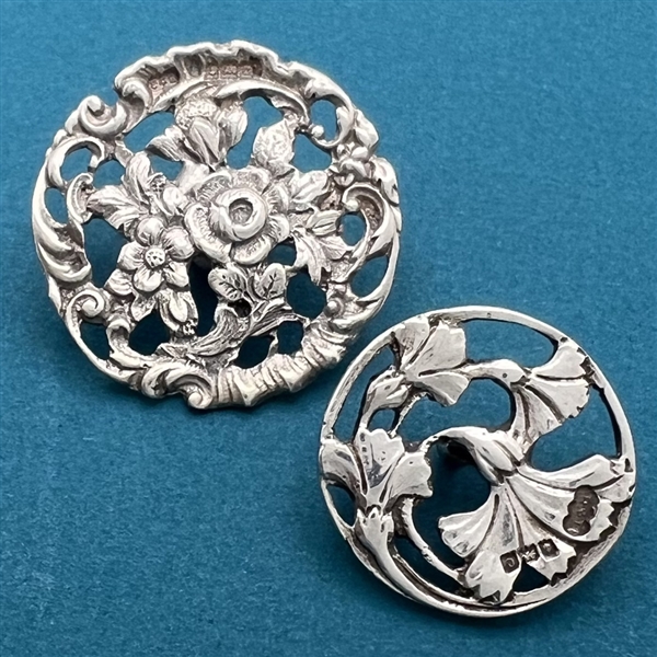 Two hallmarked silver buttons of flowers and leaves.