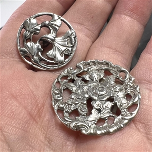 Two hallmarked silver buttons of flowers and leaves.