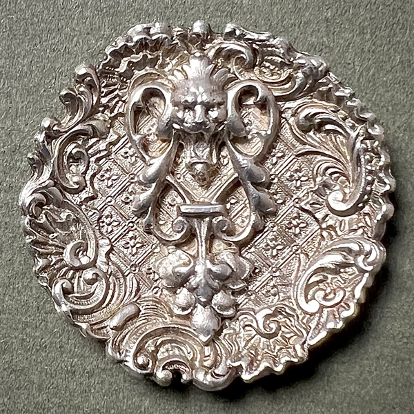 White metal lion “door knocker" button.