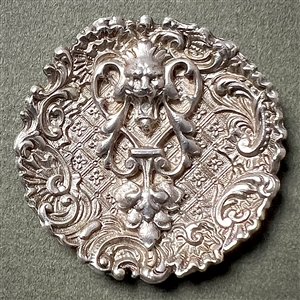 White metal lion “door knocker" button.