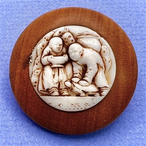 A 19th c. Wood button with a molded glass insert of Asian men.