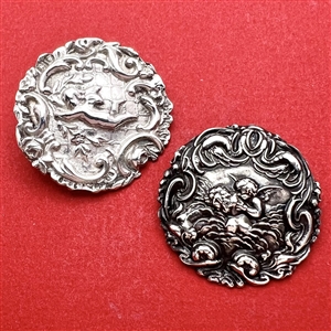 Two silver buttons of cherubs. 