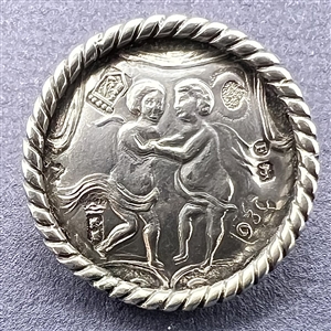 Hallmarked silver button of two men embracing.