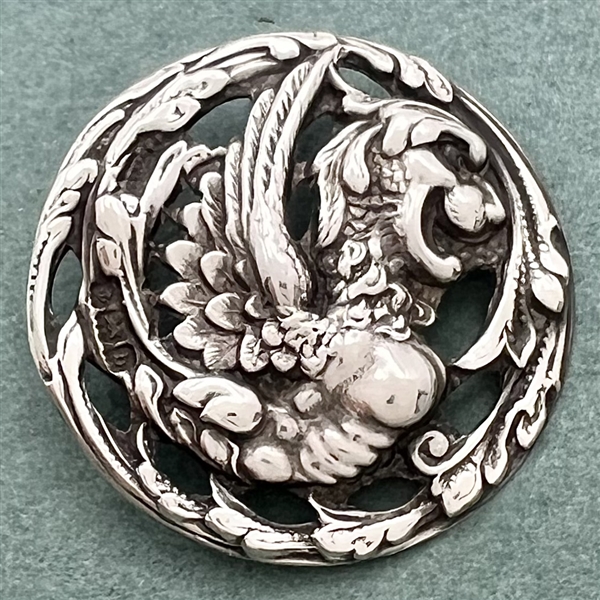 Hallmarked silver button of a fabulous creature.