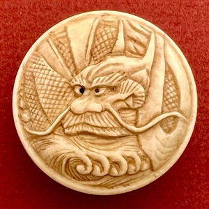 Carved natural material button of a Chinese dragon.