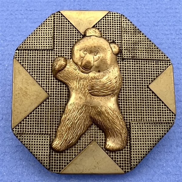 Handkerchief corner metal studio button of a bear by Phil Linley.