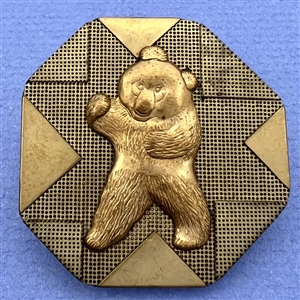 Handkerchief corner metal studio button of a bear by Phil Linley.