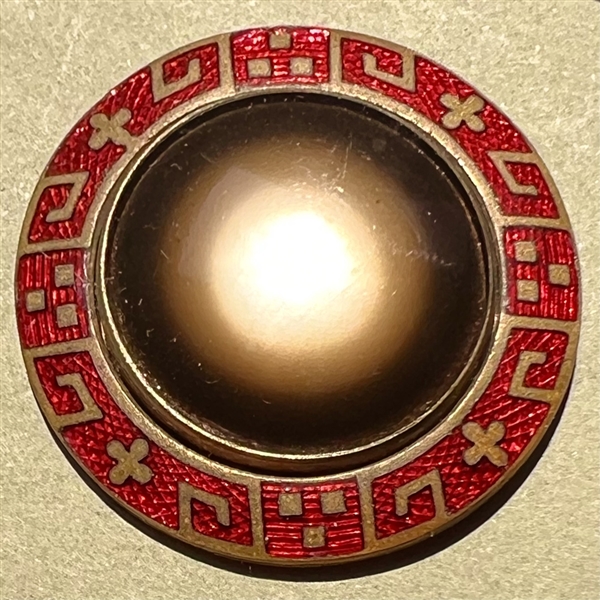 Glass in metal button with an unusual enamel border.