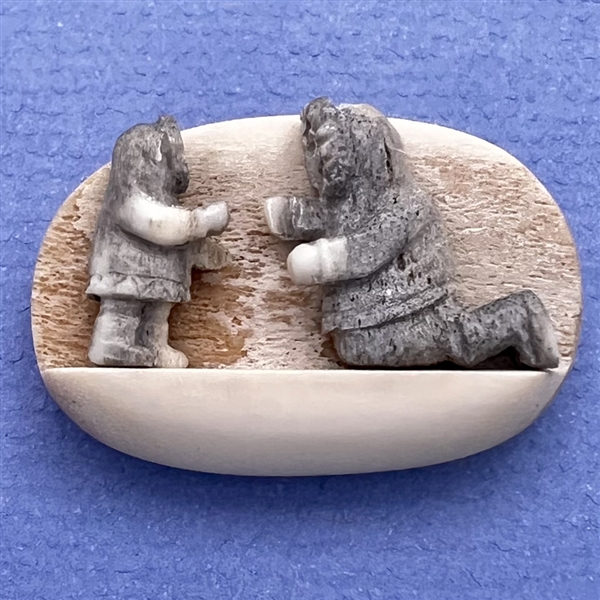 Scarce! Carved natural material studio button of an Eskimo adult and child.