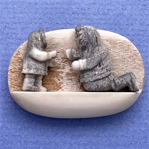 Scarce! Carved natural material studio button of an Eskimo adult and child.