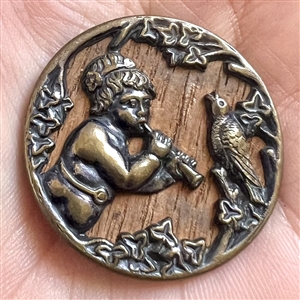 “Putto piping to a bird” brass button.