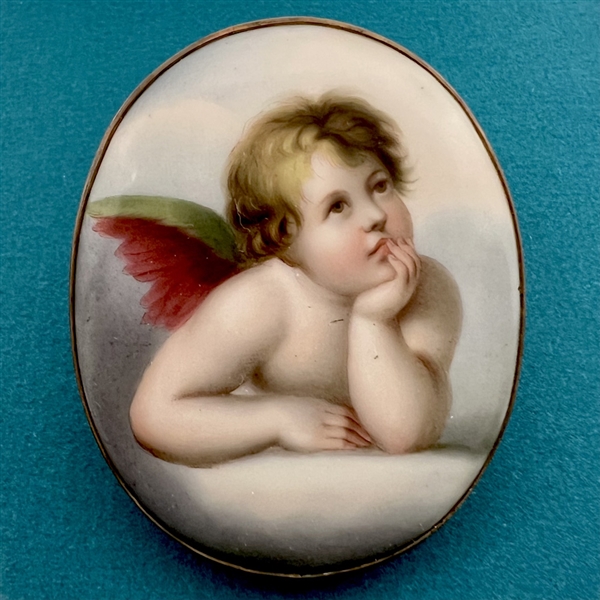 Extra large oval porcelain button of a cherub contemplating.