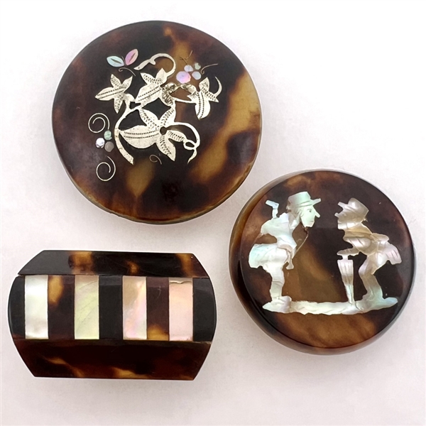 Three tortoise shell studs with inlay.