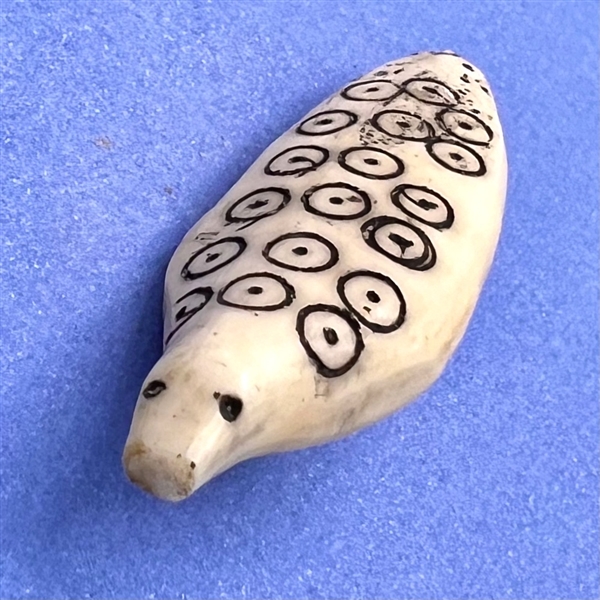 Older Inuit scrimshaw button of a realistic ringed seal.