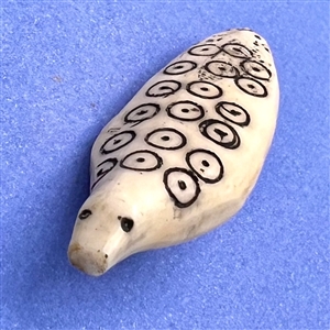 Older Inuit scrimshaw button of a realistic ringed seal.