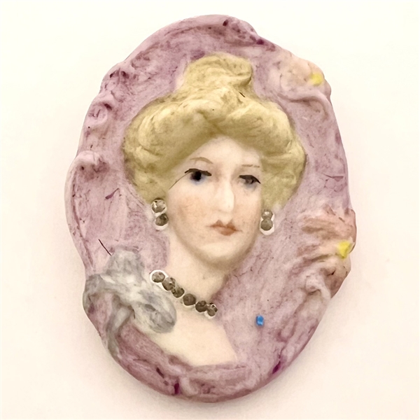 Ceramic bisque studio button of a woman  by Leah Bird.