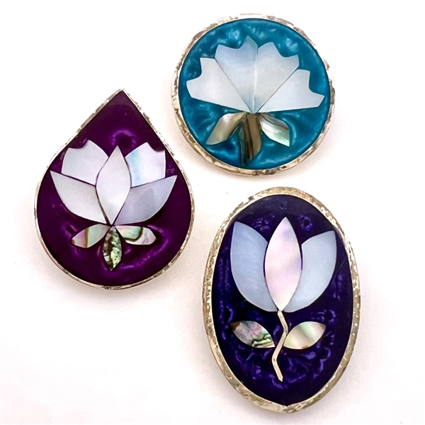 Three pearl and abalone Mexican inlay buttons of flowers.