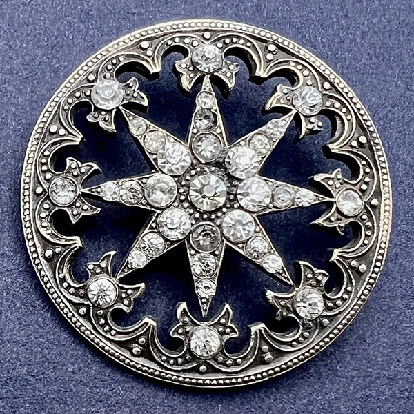 Silvered metal “jeweled” button of a star.