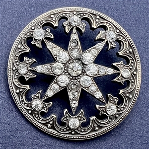 Silvered metal “jeweled” button of a star.