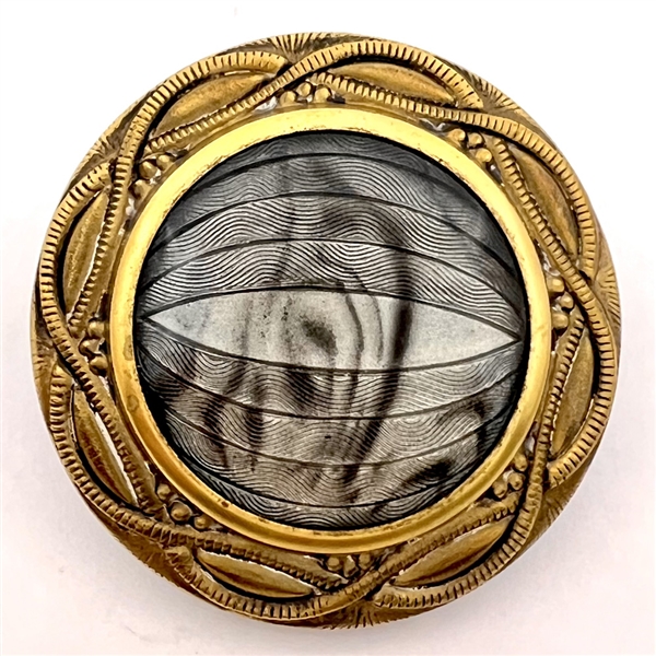 Imitation fabric reverse painted under glass set in brass button.