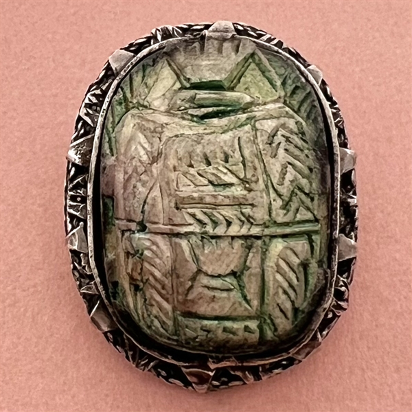 Ceramic button of an Egyptian scarab design set in metal.