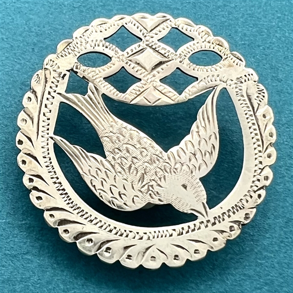 Hallmarked silver button of a flying bird.