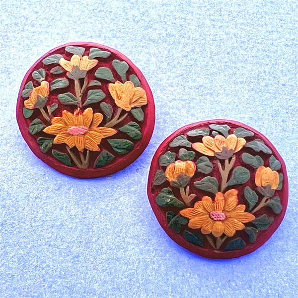 Two unusual multi-colored cinnabar buttons of flowers.