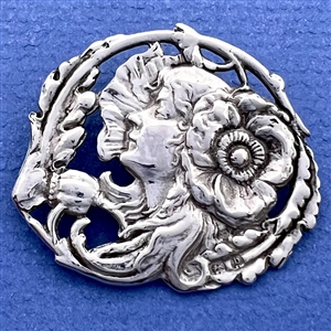 Hallmarked silver button of a woman with flower in her hair.