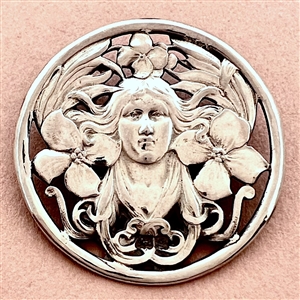 Hallmarked silver button of a woman with plant life.