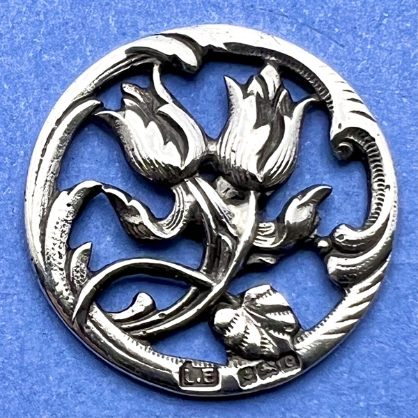 Hallmarked silver button of a tulip-like flowers.