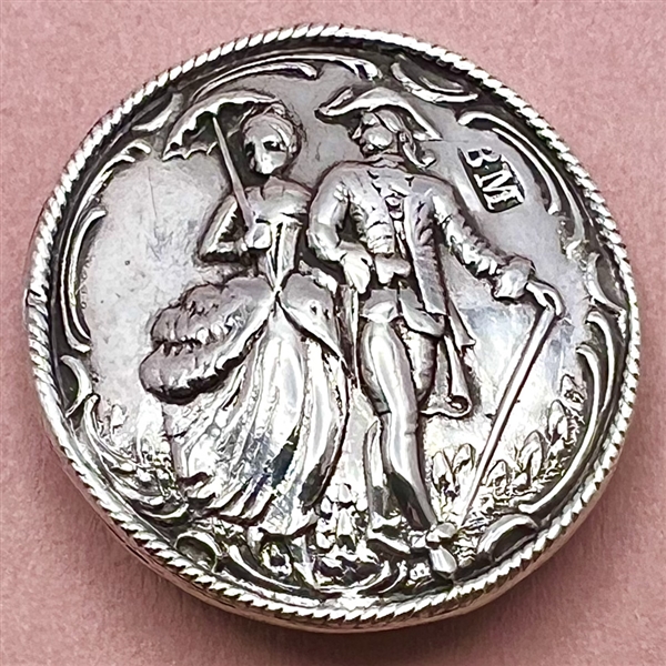 Hallmarked silver button of a couple walking.