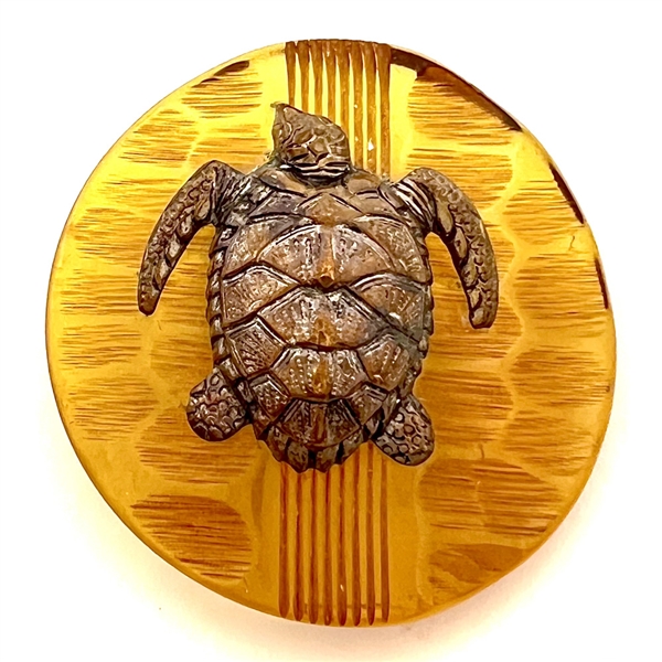 Brass sea turtle over apple juice Bakelite button.