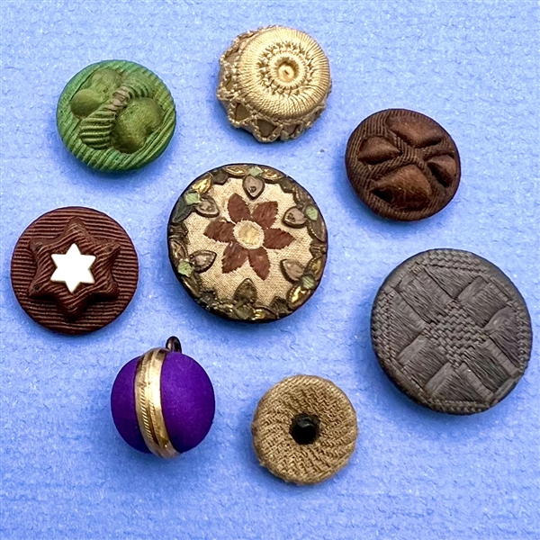 Eight assorted fabric buttons.