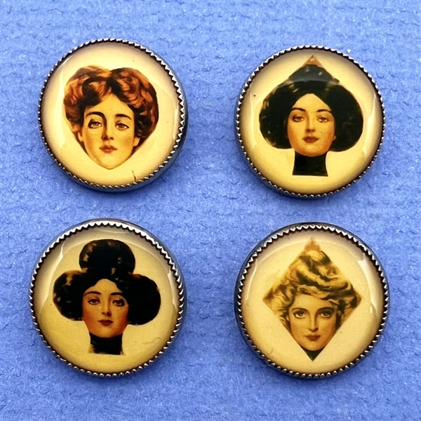 Set of four paper under celluloid sheet (?) set in metal buttons.