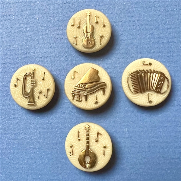 Set of five caramel glass buttons of musical instruments.