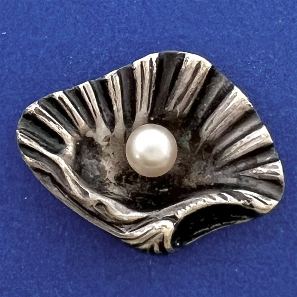 White metal button of realistic shell with pearl.