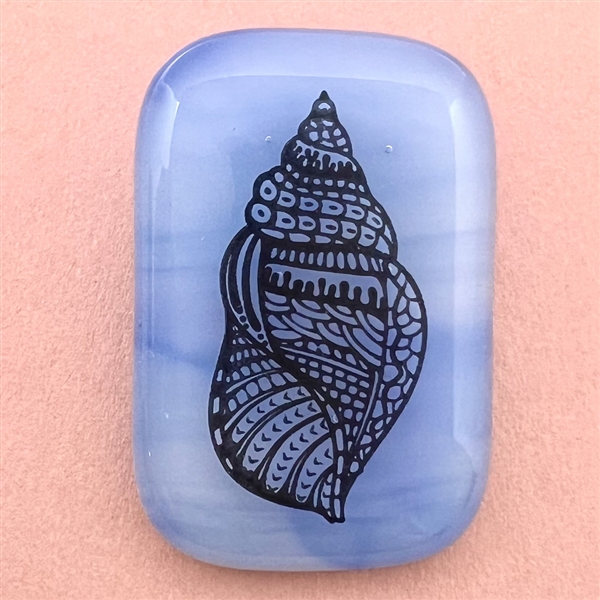 Fused glass studio button with transfer of a shell by Mona Ledwin.