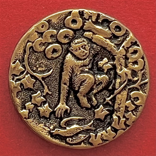 Brass button of a monkey in a tree.