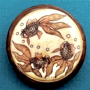 Carved material in wood button of a three koi swimming.