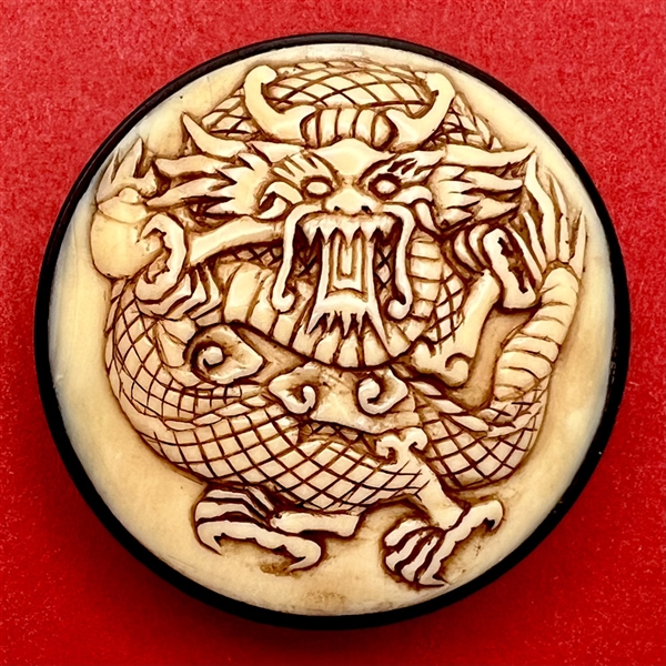 Natural material button of a dragon or mythical creature.