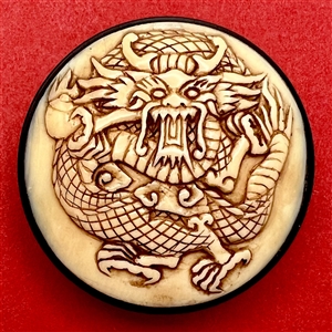 Natural material button of a dragon or mythical creature.