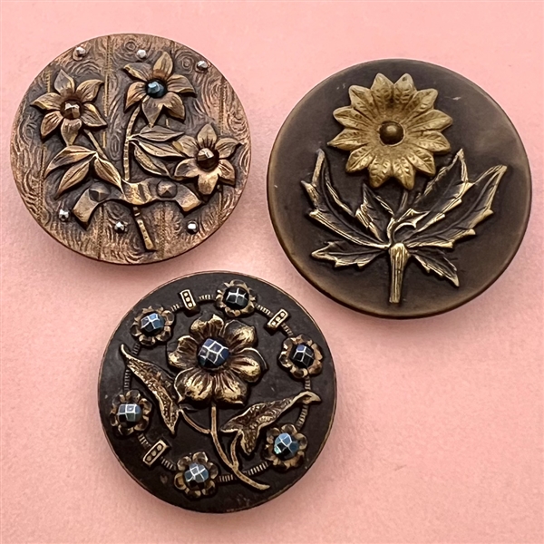 Three Victorian brass buttons of flowers.