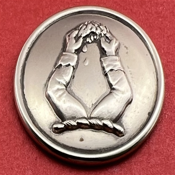 Livery crest button of hands holding a bleeding brain.